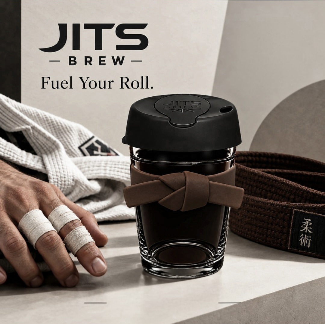 Jits Brew cup with brown belt band beside a gi and brown belt